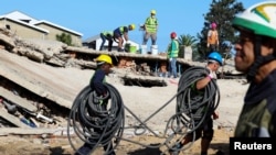 FILE - Rescuers search for construction workers trapped under a collapsed building in George, South Africa, May 8, 2024. South Africa ended the rescue efforts May 17, saying no more people were missing.