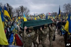 Prajurit Ukraina membawa peti mati rekan mereka Andrii Neshodovskiy saat upacara pemakaman di pemakaman di Kyiv, Ukraina, Sabtu, 25 Maret 2023. (Foto: AP/Evgeniy Maloletka)