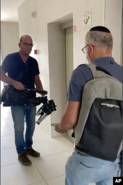In this image from video, Israeli officials seize AP video equipment from an apartment block in Sderot, Israel, on May 21, 2024.