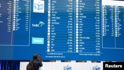 A man takes a photograph of the election results at the National Results Operation Centre of the IEC in Midrand, South Africa, June 2, 2024. 