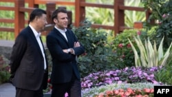 Le président chinois Xi Jinping (à gauche) et le président français Emmanuel Macron (à droite) dans le jardin de la résidence du gouverneur du Guangdong, le 7 avril 2023