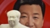 资料照：北京天安门附近一个纪念品商店里毛泽东的塑像摆在习近平纪念画盘的前面。（2018年2月27日）