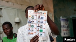 FILE - A poll worker holds a ballot during ballot counting at a polling station during the presidential election in N'Djamena, Chad, May 6, 2024. 