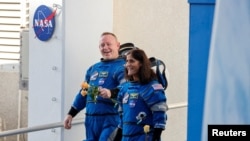 FILE - NASA astronauts Butch Wilmore and Suni Williams walk at NASA's Kennedy Space Center, in Cape Canaveral, Florida, June 5, 2024.