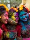 Women, with their faces smeared with colored powder, pose for a photograph as they celebrate Holi, the festival of colors, in Kolkata, India, March 25, 2024.