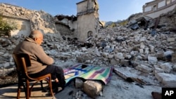 Mehmet Ismet moli se ispred ostataka džamije uništene u zemljotresu u Antakiji. (Foto: AP/Hussein Malla)