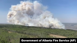 In this photo provided by the Government of Alberta Fire Service, a wildfire burns a section of forest in the Grande Prairie district of Alberta, Canada, May 6, 2023. 