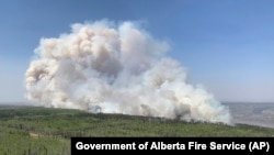 FILE - In this photo provided by the Government of Alberta Fire Service, a wildfire burns a section of forest in the Grande Prairie district of Alberta, Canada, May 6, 2023. Canadian officials have asked other countries for help fighting wildfires.