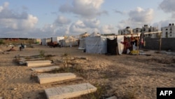 Displaced Palestinians from the eastern part of Khan Yunis set up a temporary camp in the grounds of a cemetery in the western part of the city, in the southern Gaza Strip, on July 26, 2024.