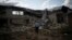 Oleksandr Pishchyk, a school director, stands in front of the school library that was destroyed by shelling in Kupiansk, Ukraine, Aug. 23, 2023.