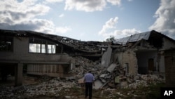 Oleksandr Pishchyk, a school director, stands in front of the school library that was destroyed by shelling in Kupiansk, Ukraine, Aug. 23, 2023.