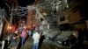 人们聚集在黎巴嫩贝鲁特南郊一栋被以色列空袭摧毁的建筑附近。(2024年7月30日)