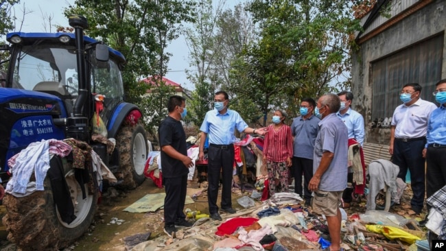 资料照：中国时任总理李克强（中）视察河南郑州洪水灾情时与灾民交谈。（2021年8月18日）
