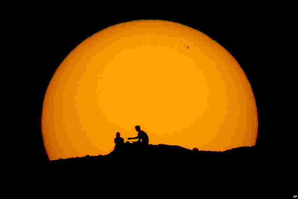 Силуети на планинари наспроти зајдисонцето во паркот Папаго, 18 февруари 2023 година, во Феникс, Аризона.