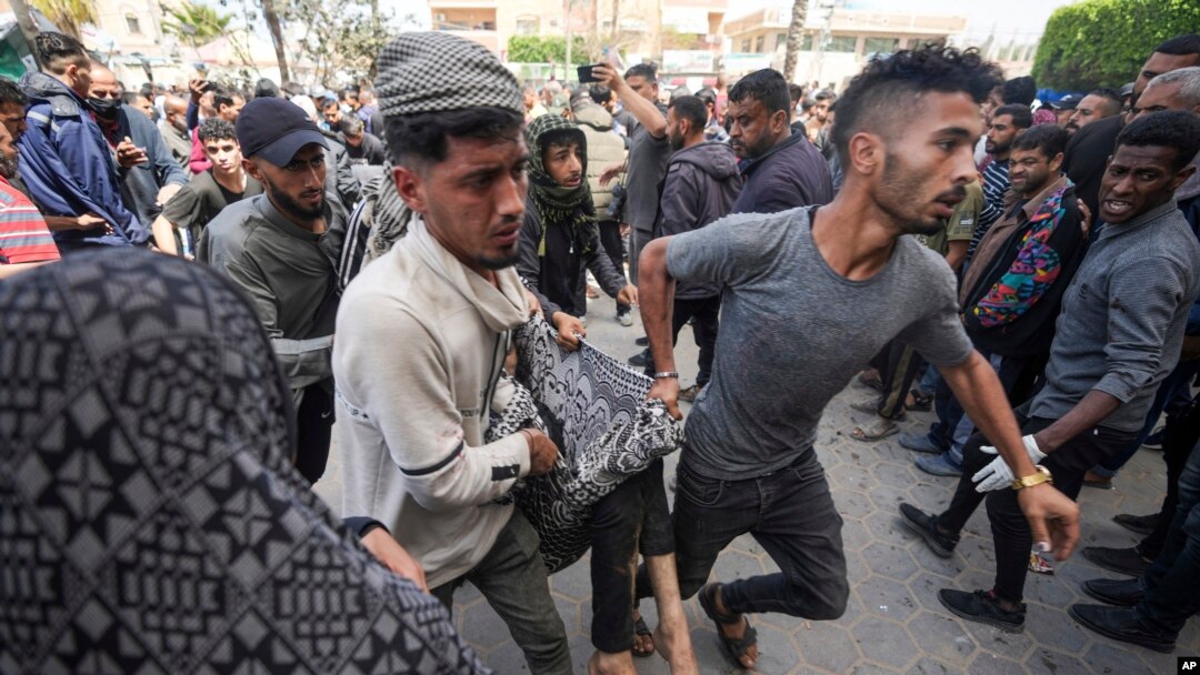Palestinians carry a wounded person following an Israeli airstrike near Al-Aqsa hospital, in Deir al Balah, Gaza Strip, March 31, 2024.