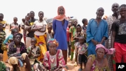 FILE - Internally displaced people wait for aid in Djibo, Burkina Faso, May 26, 2022.