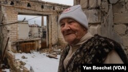 Lida, de 85 años, de pie en su apartamento del quinto piso que fue bombardeado y luego destruido por el fuego, fotografiada el 1 de abril de 2023 en Lyman, Ucrania. [Foto: Yan Boechat, VOA]