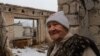 Lida, 85, stands in her fifth-floor apartment that was bombed and then destroyed by fire, in Lyman, Ukraine, April 1, 2023. (Yan Boechat/VOA)