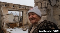 Lida, 85, stands in her fifth-floor apartment that was bombed and then destroyed by fire, in Lyman, Ukraine, April 1, 2023. (Yan Boechat/VOA)