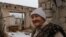 Lida, 85, stands in her fifth-floor apartment that was bombed and then destroyed by fire, in Lyman, Ukraine, April 1, 2023. (Yan Boechat/VOA)