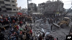 Palestinians search for bodies and survivors in the rubble of a residential building destroyed in an Israeli airstrike, in Rafah, southern Gaza Strip, Dec. 20, 2023. 