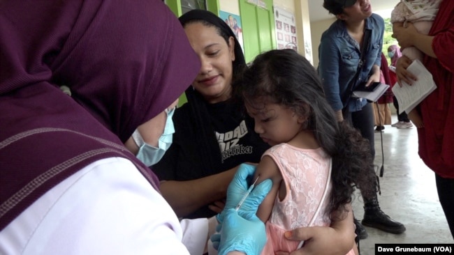 Two-year-old Alicia Musa gets vaccinated for measles and rubella at a public health clinic in Taguig, Philippines, May 18, 2023.