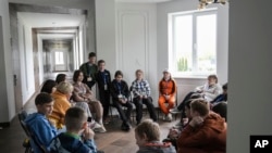 FILE - Children attend a group therapy class at the recovery camp for children and their mothers affected by the war near Lviv, Ukraine, Wednsday, May 3, 2023. 