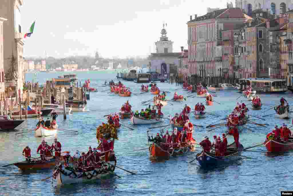 People dressed as Santa Claus row during a Christmas regatta along the Grand Canal in Venice, Italy.