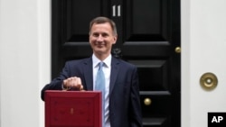 Britain's Chancellor of the Exchequer Jeremy Hunt poses for the media with his traditional Red ministerial box as he leaves 11 Downing Street for the House of Commons to deliver the Budget in London, March 15, 2023.