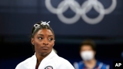 FILE - Simone Biles watches gymnasts perform after she exited the team final at the 2020 Summer Olympics, in Tokyo. Biles drew attention by pulling out of events in Tokyo because of a mental block that made her afraid to attempt certain dangerous moves. 