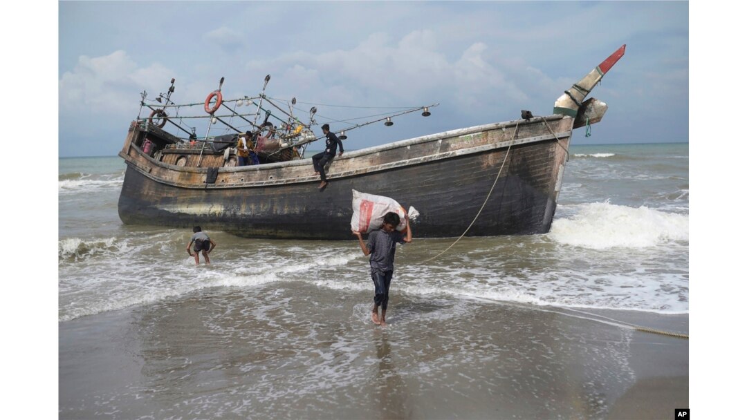 Etnis Rohingya mengumpulkan barang-barang dari perahu mereka setelah mendarat di Pantai Lampanah Leungah di Aceh Besar, Kamis, 16 Februari 2023. (Foto: AP)