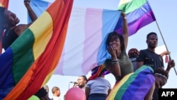 Members of Namibia's LGBTQ community wave rainbow flags during a Pride Parade in the capital Windhoek, July 29, 2017. The country's Supreme Court on March 20, 2023, sided with a lower court in denying a gay couple's citizenship application for foreign-born surrogate child.