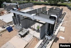 A drone image shows a 3D printer printing the walls of a home under construction in Georgetown, Texas, June 30, 2024.