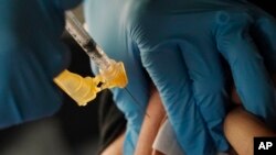 ILUSTRASI - Seorang nakes menyuntikkan vaksin penguat COVID-19 Moderna di dekat Jackson State University, Jackson, Mississippi, 18 November 2022. (AP/Rogelio V. Solis)
