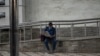 FILE - A commuter reads a newspaper outside a metro station in Kochi, Kerala state, India, Aug. 5, 2021. India is one of the most dangerous countries for media, according to Reporters Without Borders.