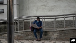 FILE - A commuter reads a newspaper outside a metro station in Kochi, Kerala state, India, Aug. 5, 2021. India is one of the most dangerous countries for media, according to Reporters Without Borders.