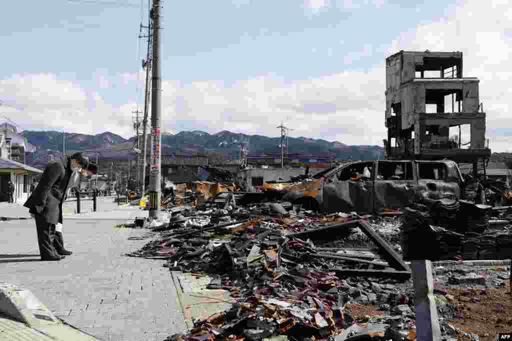 Japan's Emperor Naruhito, left, and Empress Masako, 2nd left, bow as they pay their respects at the site where a large-scale fire broke out on New Year's Day following a 7.5-magnitude earthquake in the area, in the city of Wajima, Ishikawa prefecture.