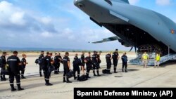 In this photo taken by UME (military emergency unit), a UME military emergency search and rescue unit board a plane at the air base in Zaragoza, Spain, Sept. 10, 2023 to help with the earthquake rescue in Morocco.