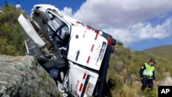 ARCHIVO - En esta fotografía proporcionada por la agencia gubernamental de noticias Andina, un oficial de policía investiga el lugar del accidente de un minibús, en Chivay, Perú, el 20 de abril de 2018.