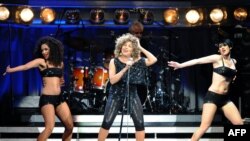 FILE - US singer Tina Turner (C) performs on stage at the P.O.P.B in Paris on March 16, 2009. Turner, 69, actually tours Europe with her "Tina!: 50th Anniversary Tour" programm.