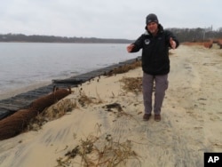 Capt. Al Modjeski, a restoration specialist with the American Littoral Society, examines a beach along the Shark River in Neptune N.J., Jan. 31, 2023. (AP Photo/Wayne Parry)