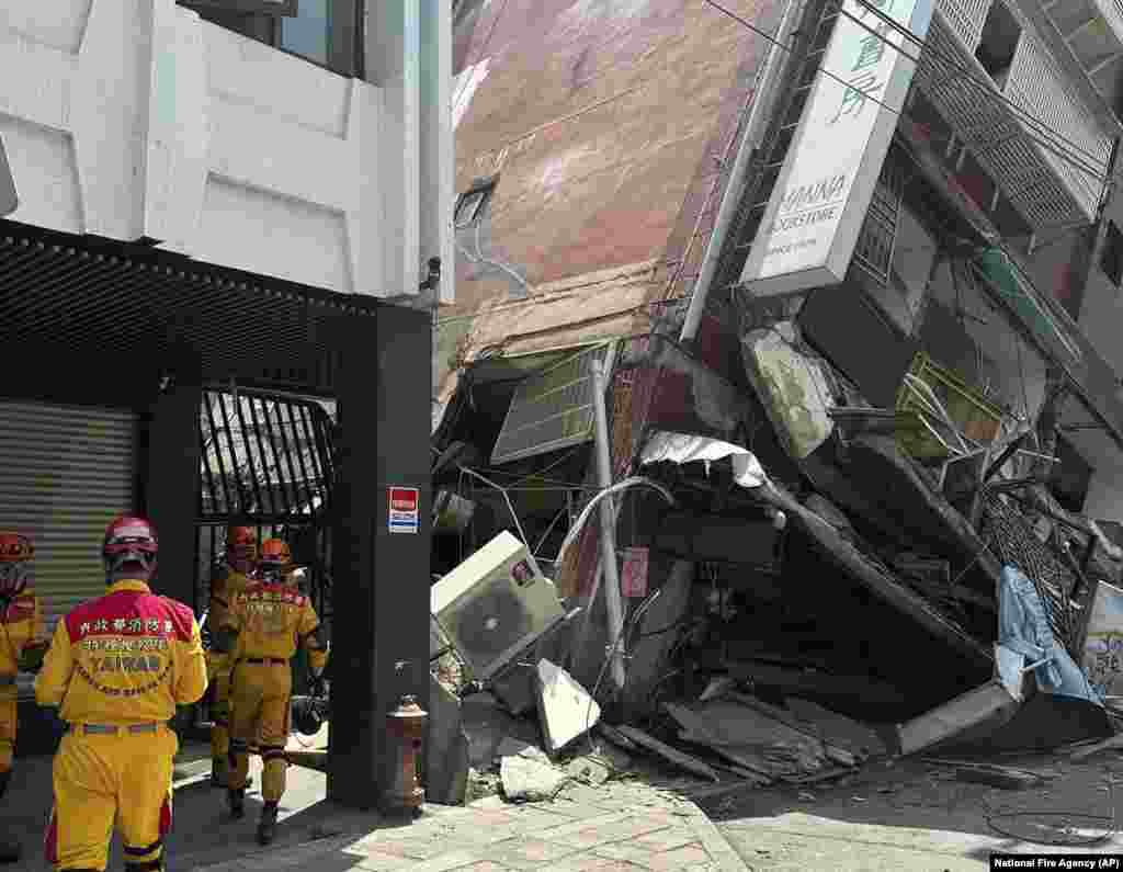 Miembros de un equipo de búsqueda y rescate llegan hasta un edificio inclinado tras el terremoto en Hualien, al este de Taiwán.