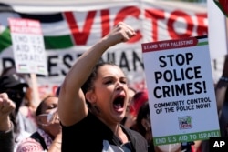 A protester yells during a demonstration before a march to the Democratic National Convention, Aug. 19, 2024, in Chicago.