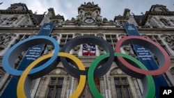 FILE: The Olympic rings ar seen in front of the Paris City Hall, in Paris, Sunday, April 30, 2023. The 2024 Olympic Games will take place from July 26 to Aug.11, 2024 in Paris an other venues. On June 20, 2023, police raided Olympics offices in an anti-corruption probe. 