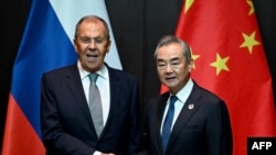 China's Foreign Minister Wang Yi, right, shakes hands with Russia's Foreign Minister Sergei Lavrov during a ministerial meeting on the sidelines of the Association of Southeast Asian Nations foreign ministers' meeting in Vientiane, Laos, on July 25, 2024.