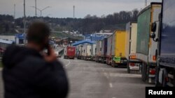 FILE - Trucks wait for crossing the Ukraine-Poland border, at the checkpoint Rava-Ruska, Lviv region, Ukraine, April 17, 2023.