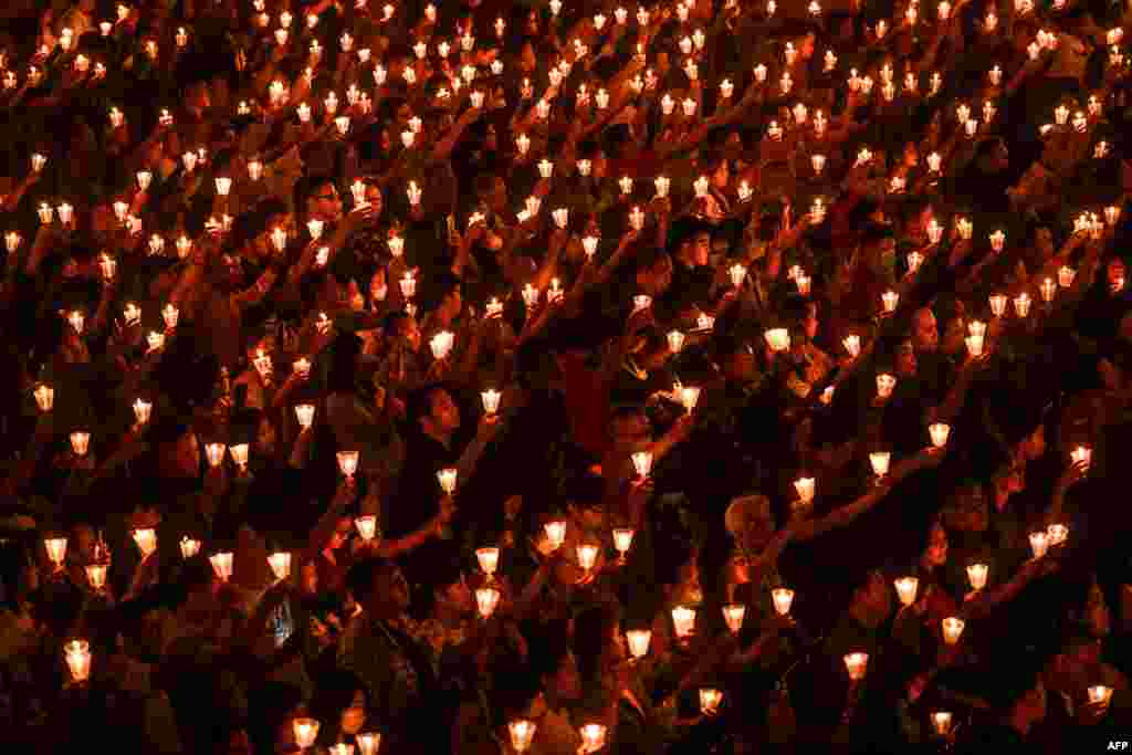 Para jemaat serempak memegang lilin dalam misa Malam Natal di Gereja Bethany di Surabaya, pada 24 Desember 2023. (Foto: AFP/Juni Kriswanto)