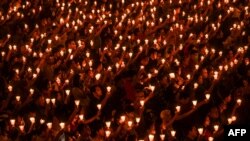 Christian devotees hold candles during a midnight Mass on Christmas Eve at the Bethany church in Surabaya, Indonesia.