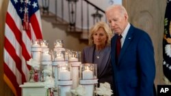 President Joe Biden, with first lady Jill Biden, looks at flowers and candles with the names of victims as he arrives to speak on the one-year anniversary of the school shooting in Uvalde, Texas, at the White House in Washington, May 24, 2023.