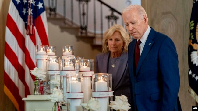 President Joe Biden, with first lady Jill Biden, looks at flowers and candles with the names of victims as he arrives to speak on the one-year anniversary of the school shooting in Uvalde, Texas, at the White House in Washington, May 24, 2023.